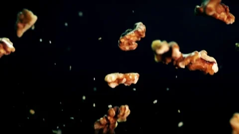 Close-up of fresh walnuts flying against a dark background in super slow motion Stock Footage 272188442