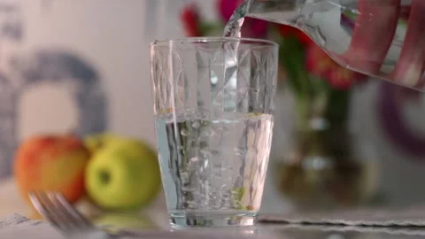 Close up of fresh water pouring into clear glass on dinner table Stock Footage 339794801