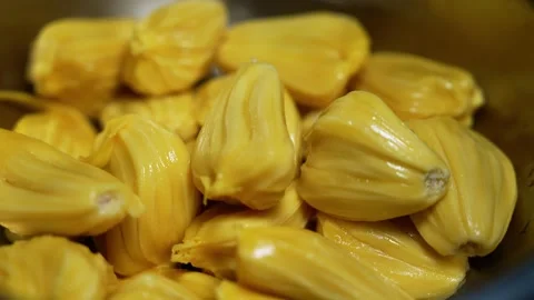 Close-up of fresh yellow jackfruit pieces piled together in a bowl, showing.. Stock Footage 339022570