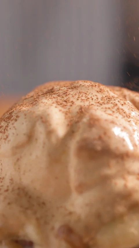 Close-up freshly baked cinnamon roll topped with a melting scoop of caramel ice Stock Footage 319899966