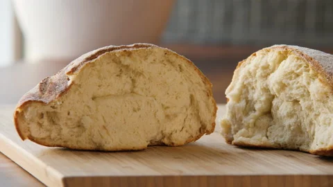 Close-up of freshly baked homemade triangular bread broken in half 스톡 동영상 168186132