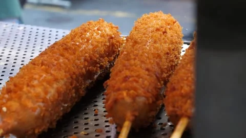 Close-up of Freshly Fried Korean Corn Dogs Resting on a Wire Rack in a Deep Frye Video stock 343587680