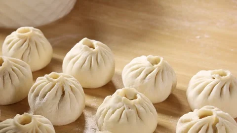 Close Up of Freshly Made Chinese Steamed Buns Baozi on Wooden Board Stock Footage 339561395