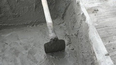 Close-up of freshly mixed wet cement in a black plastic tub with a hoe Stock Footage 333852991