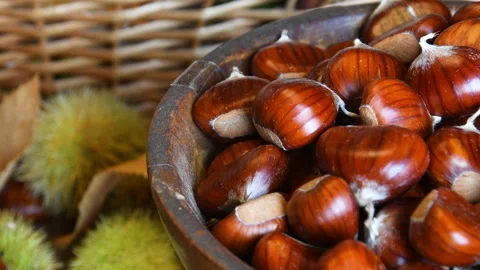 Close-up of freshly picked chestnuts inside a wooden bowl Stock Footage 164298628