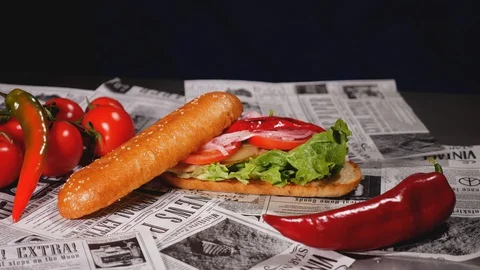 Close-up of a freshly prepared mackerel burger with fresh lettuce, tomato, onion Stock Footage 128292223