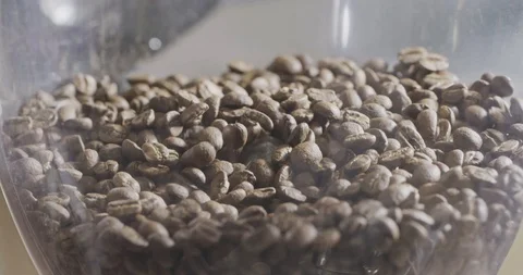 Close-up freshly roasted coffee beans poured into a coffee grinder. Slow motion Stock Footage 129637158