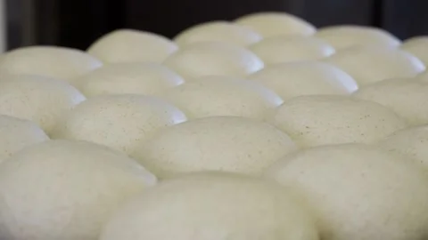 Close-up of freshly shaped bread loaves resting on a bakery table before baking Stock Footage 313532087