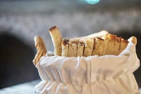 Close-up of freshly sliced bread served in a small white fabric-lined basket 스톡 사진