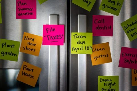 Close Up of Fridge Door With Reminder Notes Reminding to File Taxes April 18t Foto stock