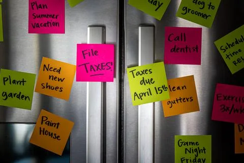 Close Up of Fridge Door With Reminder Notes Reminding to File Taxes April 15t Foto stock