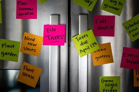 Close Up of Fridge Door With Reminder Notes Reminding to File Taxes April 17t Foto stock