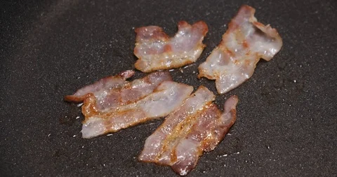 Close-up of fried bacon in hot pan, fat, crisp, cuisine, thin slices of meat Stock Footage 120897069
