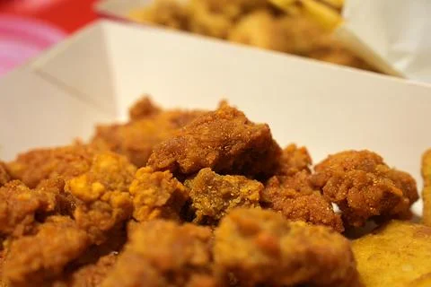 Close-up Fried breaded chicken fillet in white cardboard box isolated on burr Stock Photos