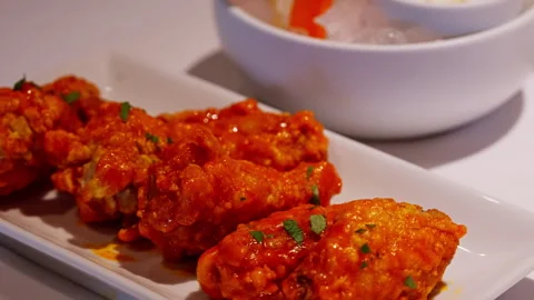 Close-up of fried buffalo wings coated in a rich red sauce, highlighting the Stock Footage 282766508