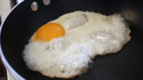 Close up to fried egg while cooking on a frying pan preparation process hom.. Stock Footage 248777911