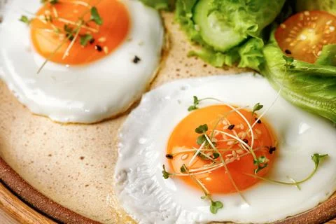 Close up of fried eggs with micro greens, breakfast with eggs, lettuce and .. Stock Photos
