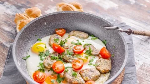 Close up fried eggs with vegetable nuggets in a gray ceramic frying pan. Tast Foto stock