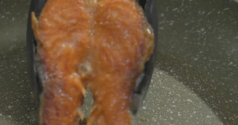 Close-up of fried fish in a frying pan. Red salmon frying in slow motion Stock Footage 252728640