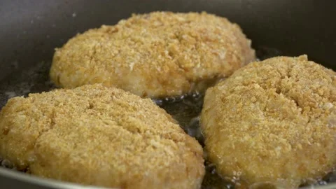 Close-up of fried juicy cutlets in breadcrumbs in a pan. Bubbles of boiling oil. Stock-Footage 138707004