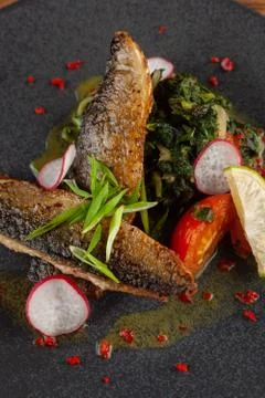 Close up of fried mackerel fish with vegetable garnish: spinach in coconut mi Stock-Fotos