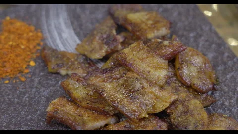 Close-up of Fried Meat Slices on Stone Board with Seasoning Stock Footage 328526699