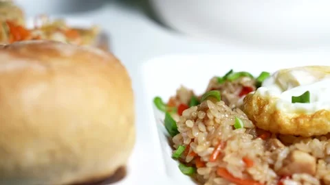 Close-up of fried rice with vegetables, topped with fried egg   Stock Footage 310929578