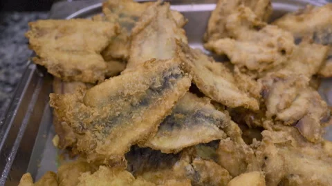 Close-up of fried small fish in a metal tray Stock Footage 330911631