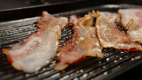 CLOSE UP: Fried strips of bacon on a pan Видео 94443577