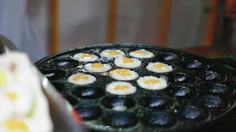 Close up of fried thai quail eggs in aebleskiver pan. Popular street food in Stock Footage 295836279