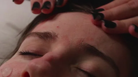 Close up of friend gently spreading moisturizing face cream on girl's forehea 库存影片 344877032