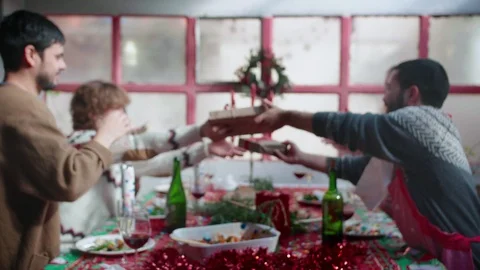 Close up of friends presenting packed Christmas gifts during beautiful decorated Stock Footage 120284102