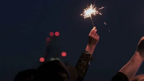 Close Up of friends while they keep bright sparkling lights and waving hands Stock Footage 109091390