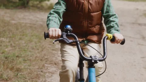 Close up front boy holding handlebar cycling alone Stock Footage 317554066