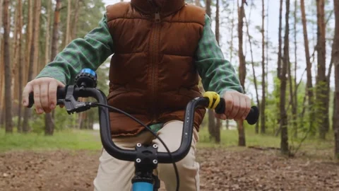 Close front boy holding handlebar riding alone Stock Footage 317554362