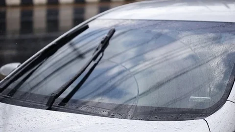 Close up front of car parking at outdoor while raining Stock Footage 76237331
