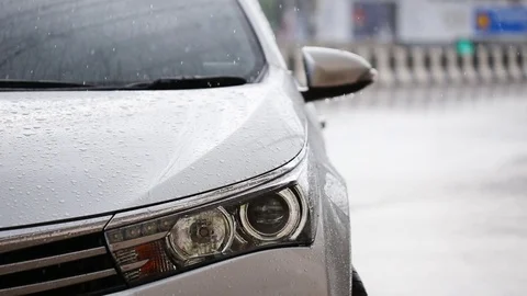 Close up front of car parking at outdoor while raining Stock Footage 76237423