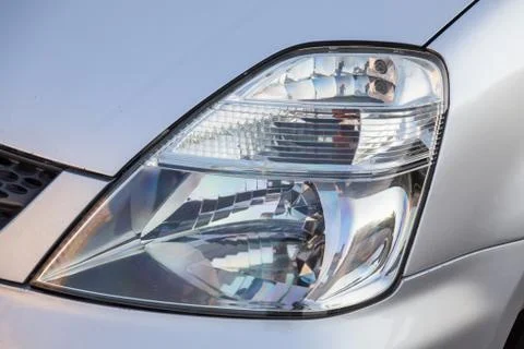 Close-up of the front glass transparent headlight of a Japanese car in silver Stock Photos