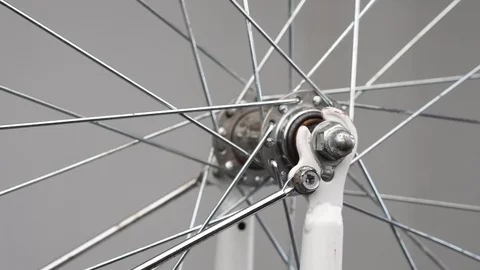 Close-up front hub with knitting needles on a bicycle fork Stock Footage 115125847