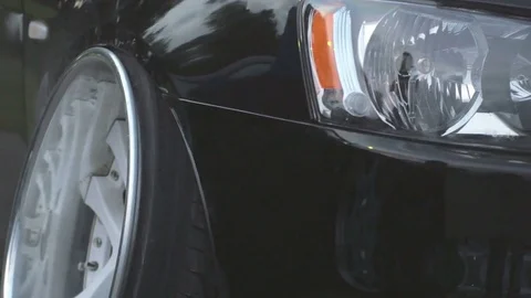 Close up front of new black luxury car parking on the asphalt road, 4k Video stock 77625013