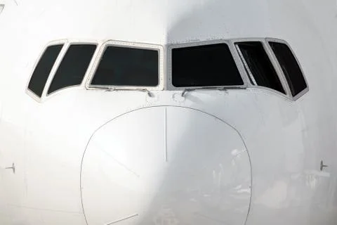 Close front outside view of a white big jet plane cockpit. Stock Photos