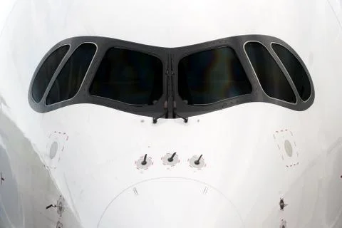 Close front outside view of a white big jet plane cockpit. Stock Photos