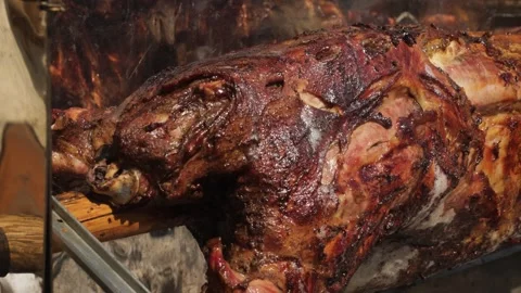 Close up of the front part of carcass of the calf baked on the grill, rotates on Stock Footage 248212070