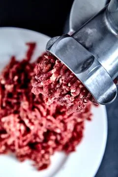 Close up front part of mincing-machine with mincemeat in Stock Photos
