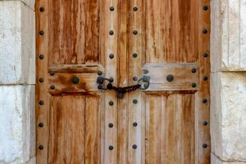 Close-up front shoot of ancient handmade wooden door on masonry stone buildin Stock Photos