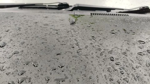 Close up from the front shot of rain on a black car hood 動画素材 198678675