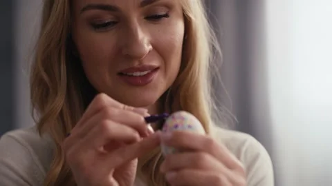 Close up front view of cheerful caucasian woman decorating easter eggs in the do Stock-Footage 170489124