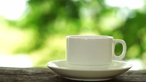 Close-up front view of a cup of tea Coffee with white saucers on a wooden tab 動画素材 158155770