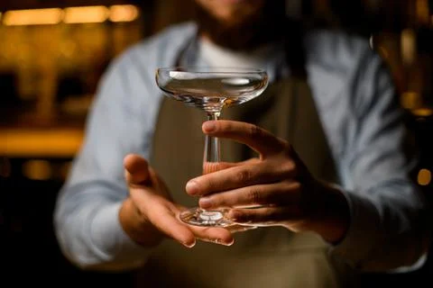 Close-up front view on elegant transparent wine glass in male hands Foto stock