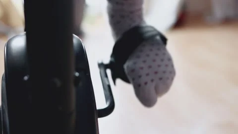 Close-up front view of a foot pedaling a stationary exercise bike at home 스톡 동영상 336009895